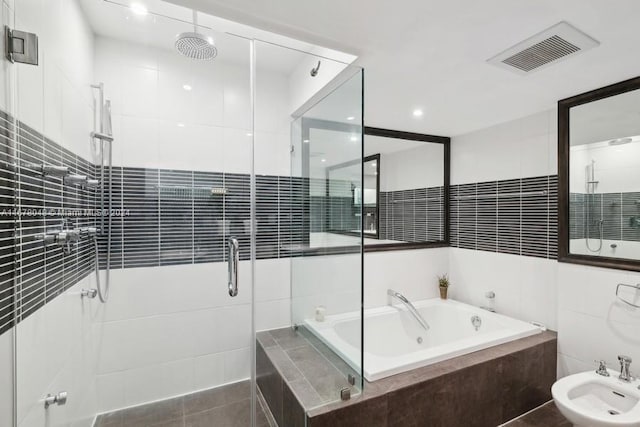 bathroom featuring tile walls, separate shower and tub, a bidet, and tile patterned flooring