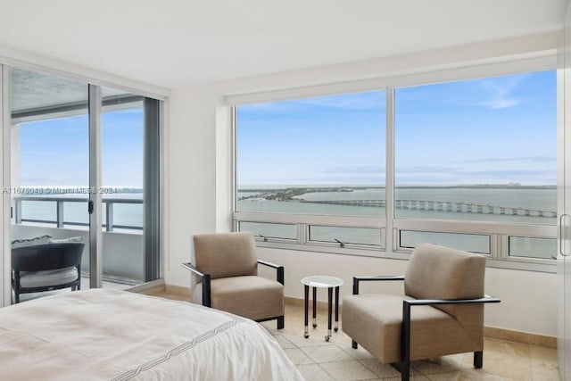 bedroom featuring multiple windows and a water view