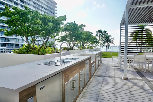 view of patio / terrace featuring a water view and exterior kitchen