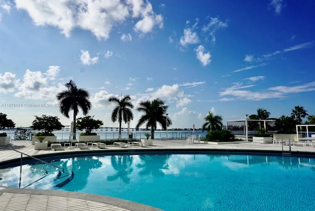 view of pool featuring a patio area and a water view