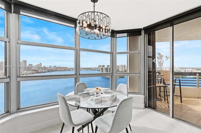 sunroom with a water view, a healthy amount of sunlight, and a chandelier