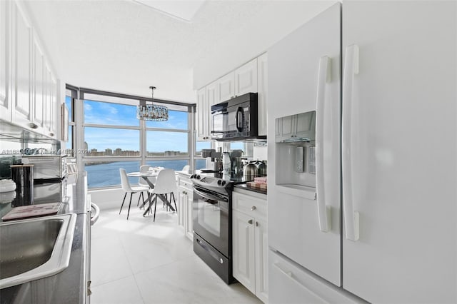 kitchen featuring decorative light fixtures, white cabinets, white fridge with ice dispenser, a water view, and electric stove