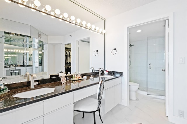 bathroom featuring vanity, toilet, and a shower with shower door