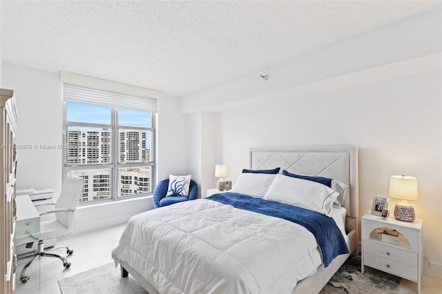 bedroom with light tile patterned floors and a textured ceiling