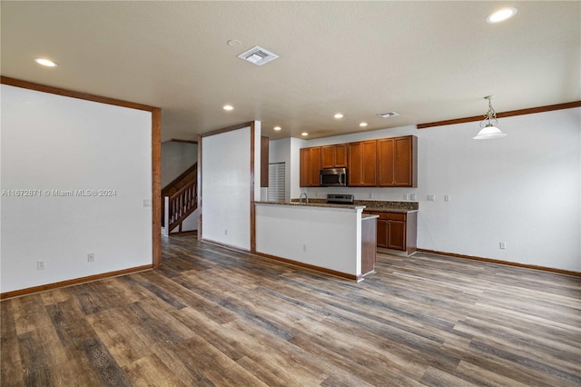 kitchen with dark hardwood / wood-style flooring, hanging light fixtures, sink, and kitchen peninsula