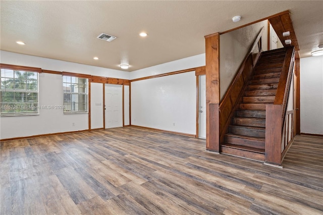 spare room featuring dark wood-type flooring and a textured ceiling