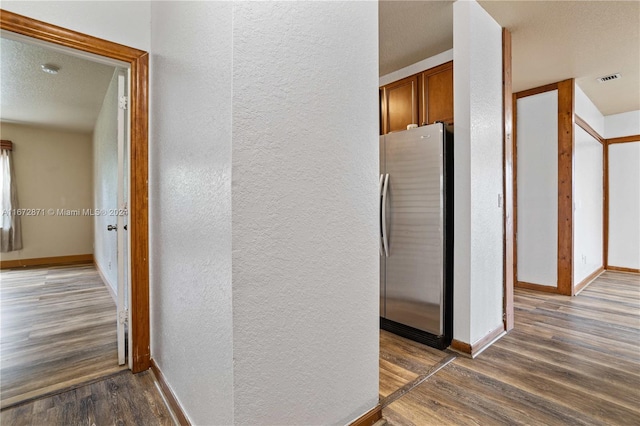 corridor with dark wood-type flooring and a textured ceiling