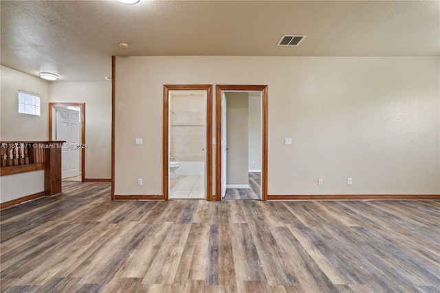 spare room featuring hardwood / wood-style floors and a textured ceiling