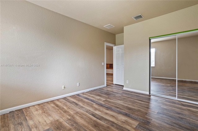 unfurnished bedroom with hardwood / wood-style floors and a closet