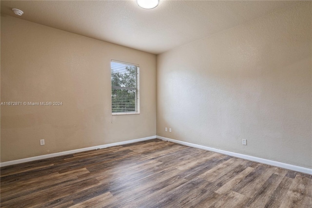 empty room with dark hardwood / wood-style flooring