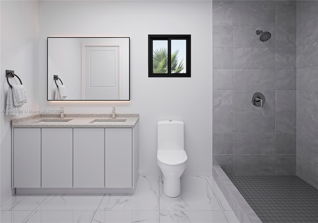 bathroom with vanity, toilet, and tiled shower