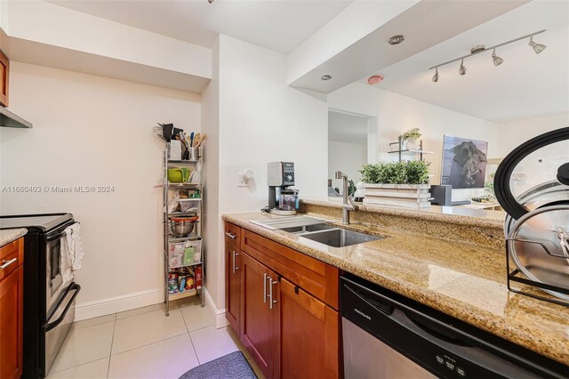 850 N Miami Ave Unit W-906, Miami, FL 33136 - kitchen featuring stainless steel appliances, light stone countertops, light tile patterned floors, and brown cabinets