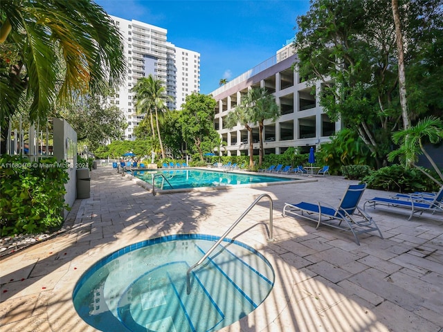 view of pool featuring a patio and a community hot tub