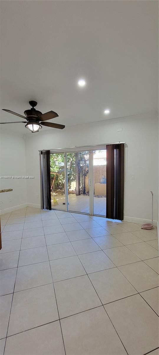 tiled empty room with ceiling fan