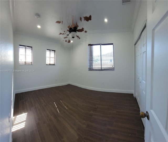 interior space with a wealth of natural light, crown molding, and dark wood-type flooring