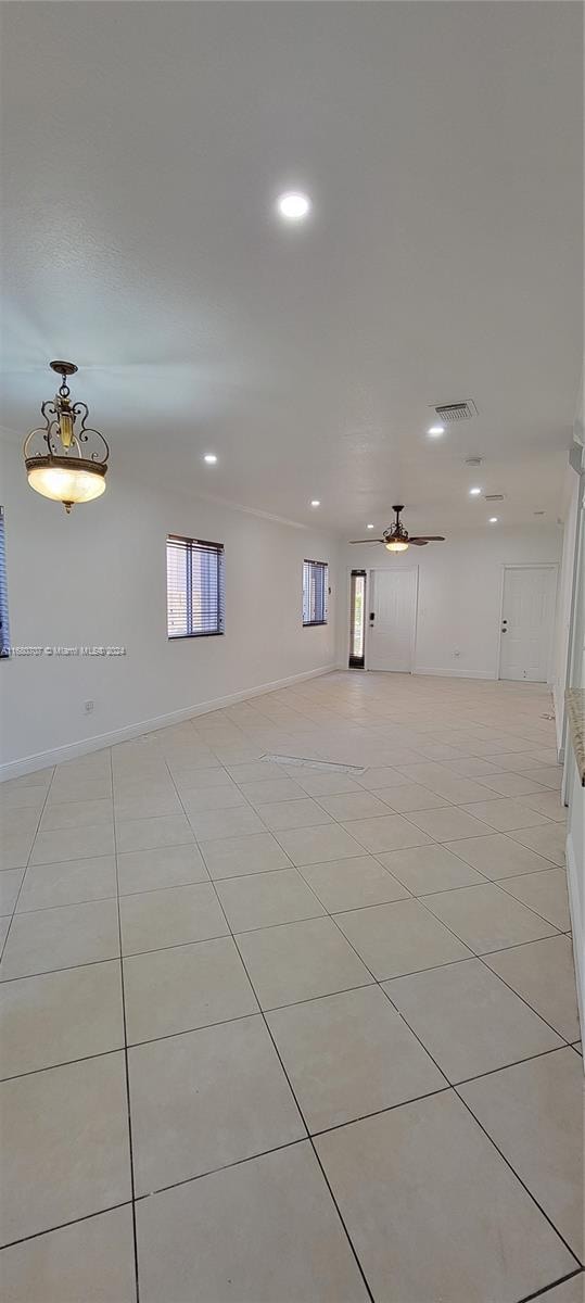 spare room featuring light tile patterned floors, a wealth of natural light, and ceiling fan