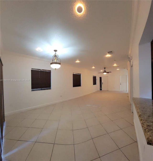 tiled spare room featuring ceiling fan and crown molding