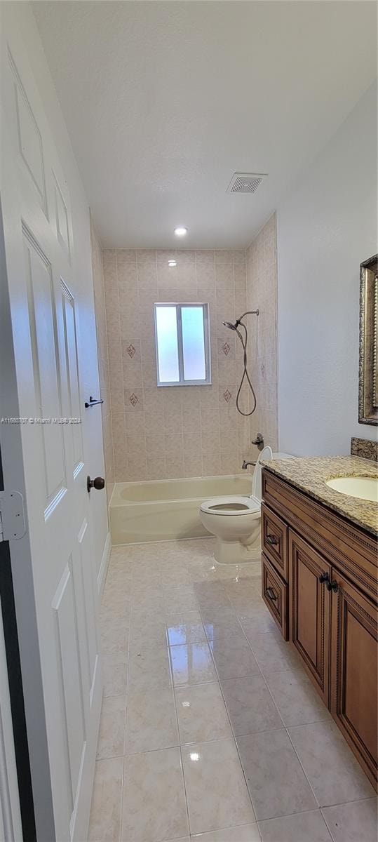 full bathroom featuring tile patterned floors, vanity, toilet, and tiled shower / bath