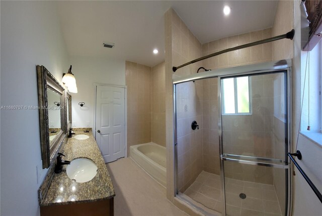 bathroom featuring vanity and independent shower and bath