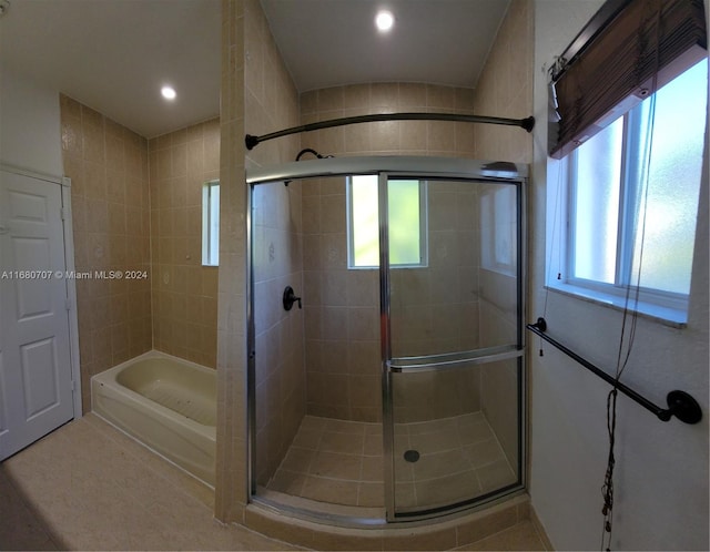 bathroom featuring a wealth of natural light and a shower with shower door