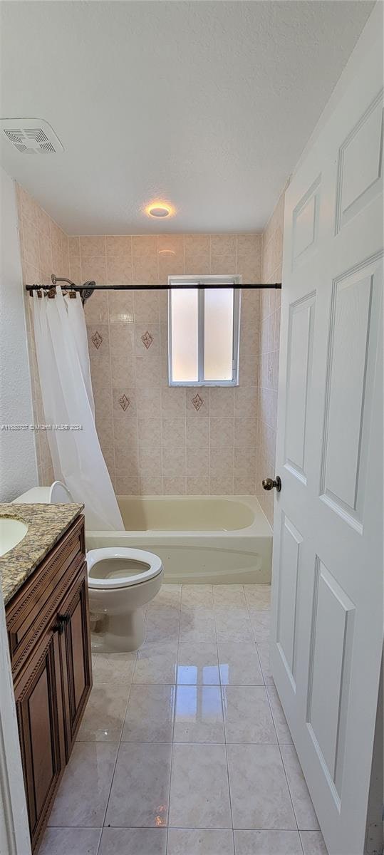 full bathroom with tile patterned flooring, vanity, shower / bath combination with curtain, and toilet