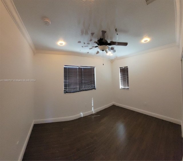 empty room with dark hardwood / wood-style flooring and crown molding