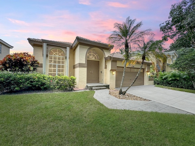 mediterranean / spanish house featuring a yard and a garage