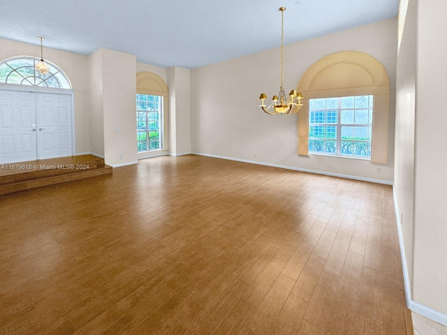 foyer with hardwood / wood-style floors and an inviting chandelier