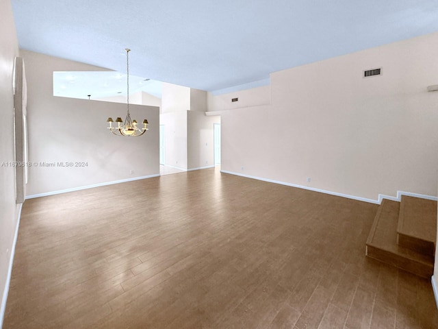 unfurnished living room featuring lofted ceiling, a chandelier, and hardwood / wood-style floors