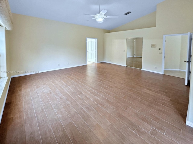 empty room with lofted ceiling, hardwood / wood-style flooring, and ceiling fan