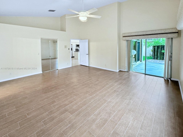 unfurnished living room featuring ceiling fan, high vaulted ceiling, and hardwood / wood-style floors