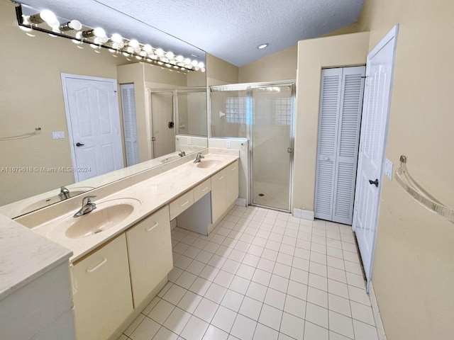 bathroom featuring vanity, tile patterned floors, a textured ceiling, and walk in shower