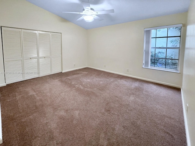 unfurnished bedroom with lofted ceiling, carpet floors, a closet, and ceiling fan