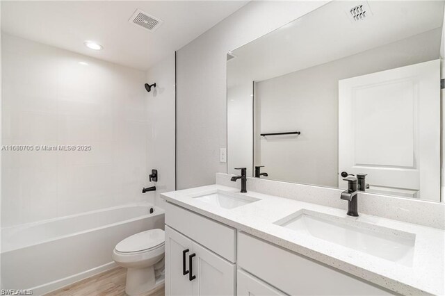 full bathroom with vanity, toilet, tub / shower combination, and hardwood / wood-style floors