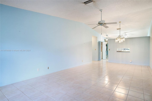 tiled empty room featuring lofted ceiling, a textured ceiling, and ceiling fan