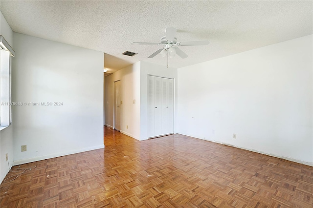 spare room with parquet flooring, a textured ceiling, and ceiling fan