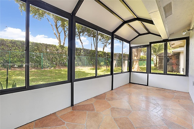 unfurnished sunroom featuring lofted ceiling with beams