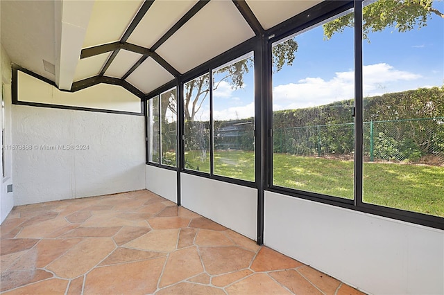 unfurnished sunroom featuring vaulted ceiling