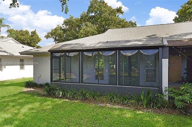 back of property featuring a yard and a sunroom