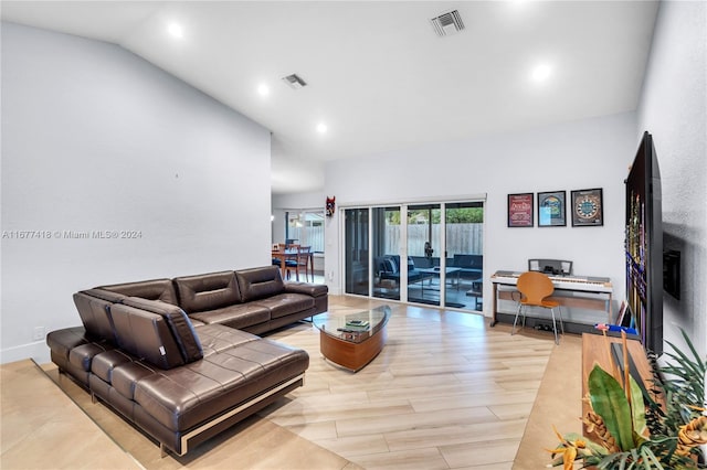 living room with light hardwood / wood-style flooring and high vaulted ceiling