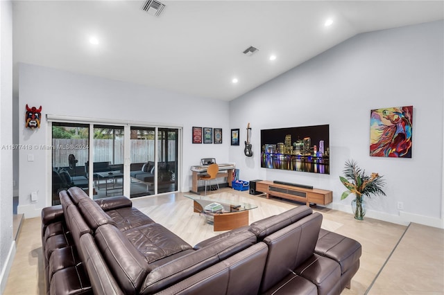 living room with light tile patterned floors and high vaulted ceiling