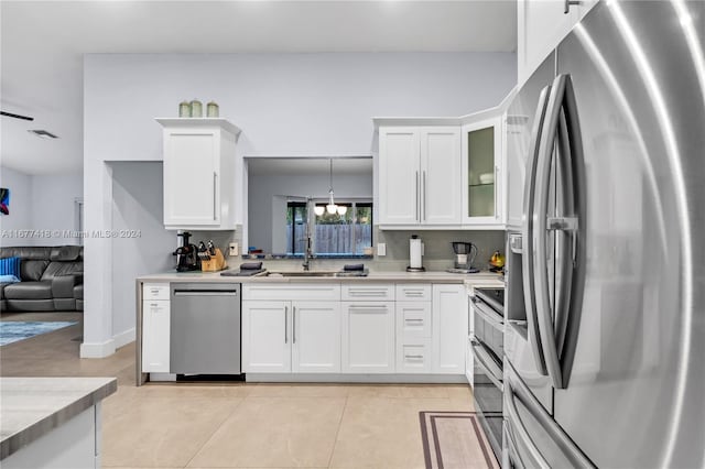 kitchen featuring hanging light fixtures, white cabinetry, sink, and appliances with stainless steel finishes