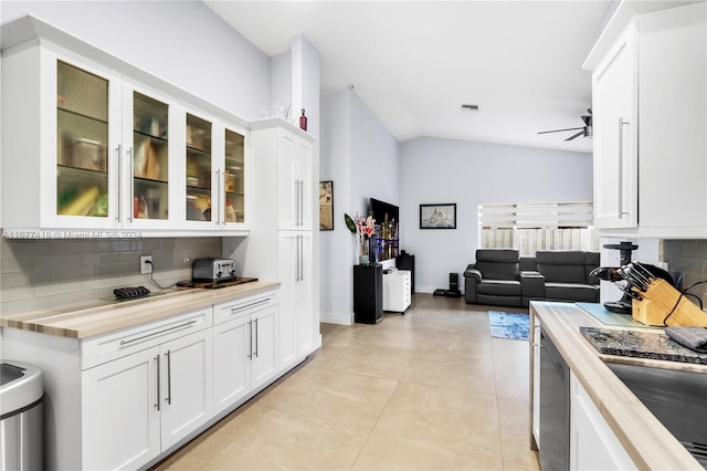 kitchen with butcher block counters, ceiling fan, tasteful backsplash, lofted ceiling, and white cabinets