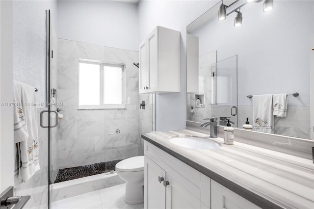 bathroom with vanity, toilet, and a shower with door