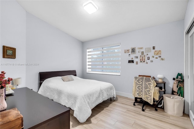 bedroom with lofted ceiling and light wood-type flooring