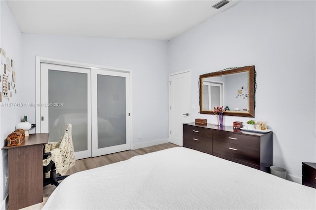 bedroom featuring light hardwood / wood-style floors and lofted ceiling