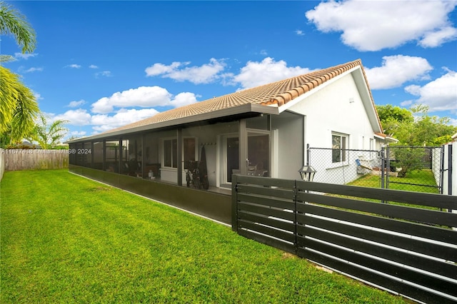 back of house with a sunroom and a yard