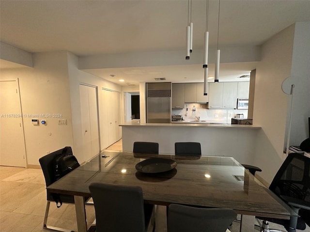 tiled dining room featuring sink