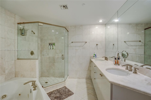 bathroom with separate shower and tub, tile patterned flooring, vanity, and tile walls