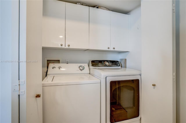 washroom with washing machine and dryer and cabinets